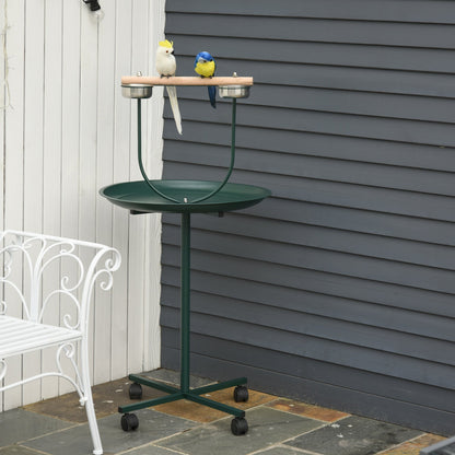 A green bird perch stand with four wheels, shown outdoors with two decorative birds on the perch