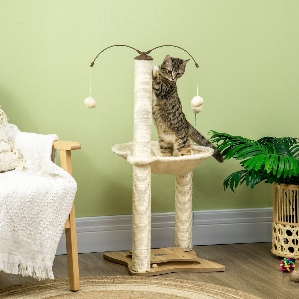 A tabby kitten plays on the cat tree in a living room setting