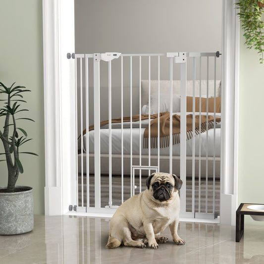 The tall dog gate is installed in a doorway, with a pug sitting in front and a bedroom visible beyond