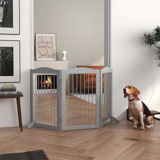 The pet gate positioned in a doorway with a beagle sitting on the wooden floor nearby