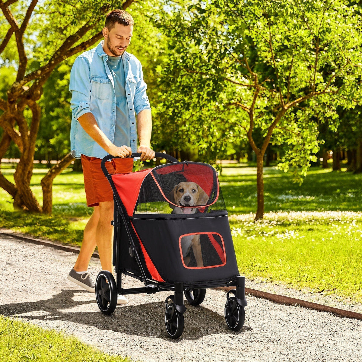 Man pushing a dog carrier stroller with a dog inside while walking on a path
