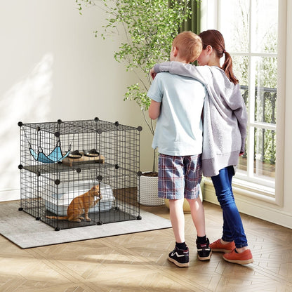 Two children looking at the cat house enclosure with a cat inside
