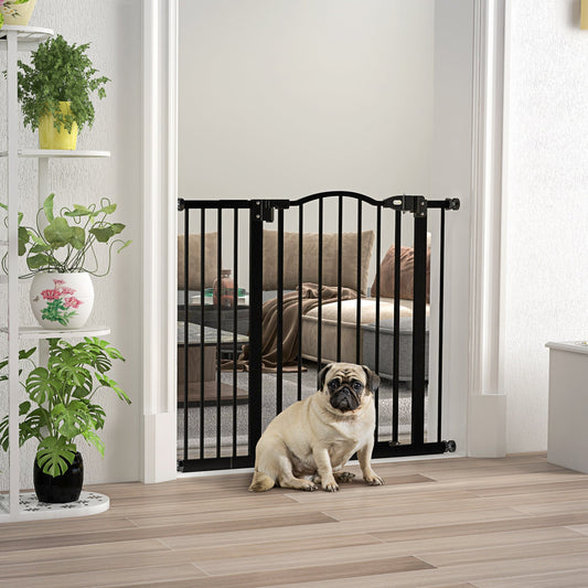 Black metal dog gate installed in a doorway with a pug sitting in front of it