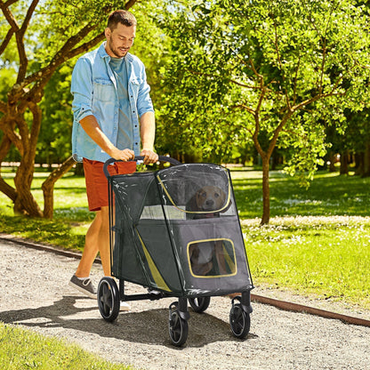 Man pushing the grey pet travel stroller with a dog inside through a park