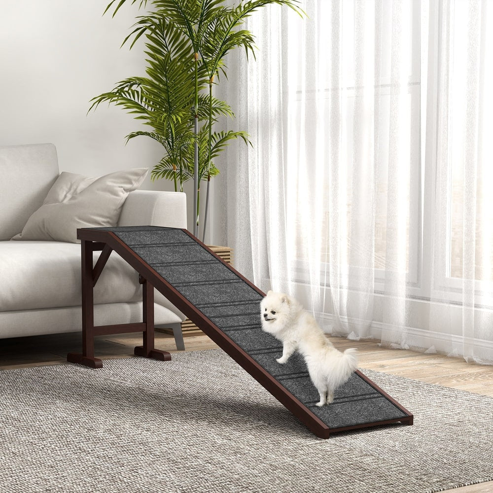 The pet ramp positioned next to a sofa with a small white dog walking up the carpeted slope