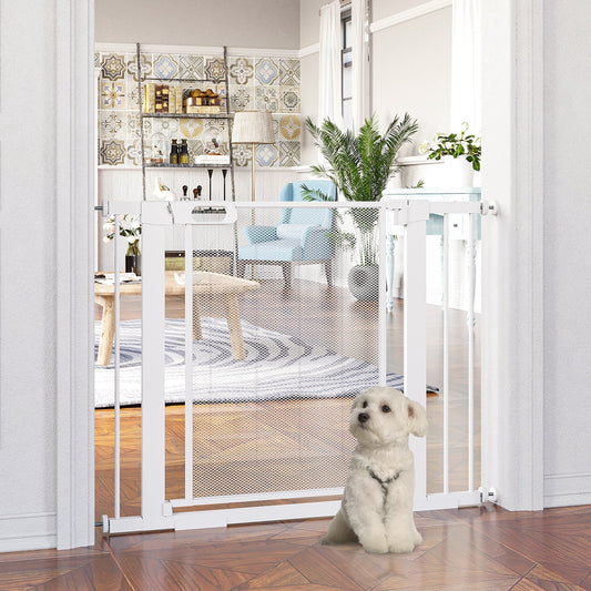 The dog gate installed in a doorway with a small white dog sitting in front of it