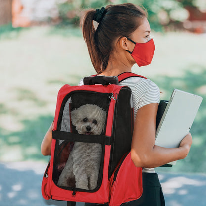 A woman wearing a face mask carries a small white dog in the red pet carrier backpack