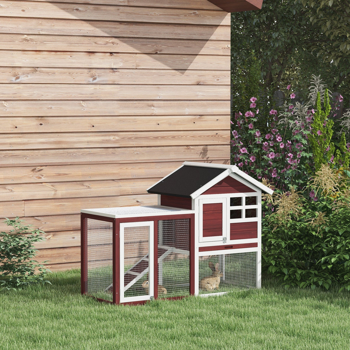 Wooden guinea pig hutch with a run set up on a lawn in front of a wooden shed