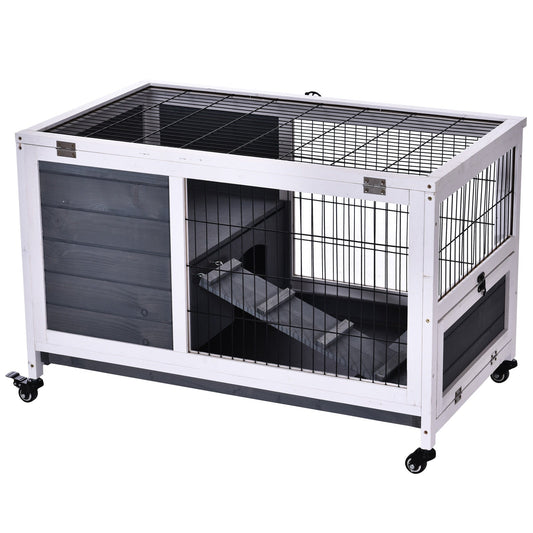 The grey and white wooden indoor hutch with wheels and a ramp inside