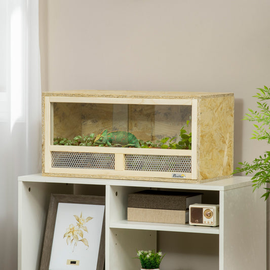 The reptile house is shown on a shelf with a chameleon inside, decorated with plants