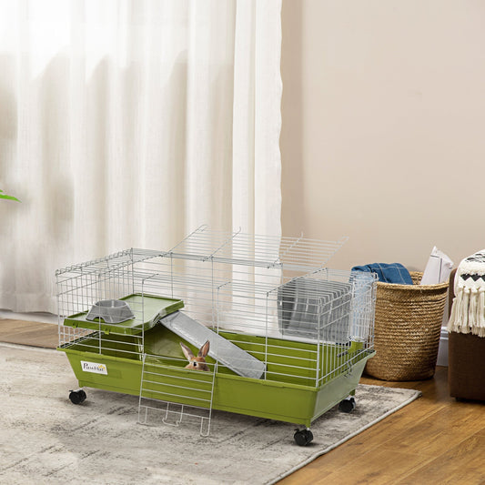 The small animal cage placed on a rug in a living room with a rabbit inside the green base