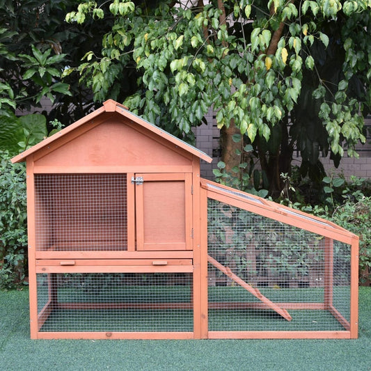 The guinea pigs hutch standing on a green lawn in front of leafy garden plants