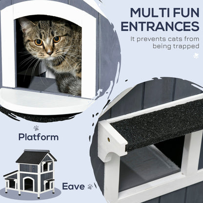 Close-up of the grey wooden cat house showing multiple entrances and a platform area for cats