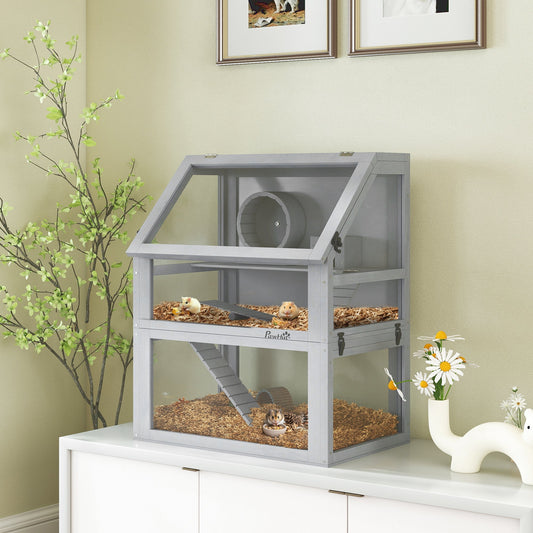 The hamster hutch in a room, showing two hamsters inside with bedding and accessories