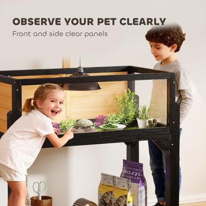 Two children looking at a tortoise inside the reptile house through the clear side panels