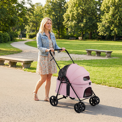 The dog stroller being pushed by a woman along a path in a green park
