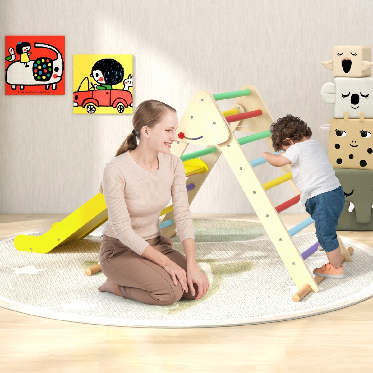 The climbing frame with a slide being used by a toddler while an adult watches nearby
