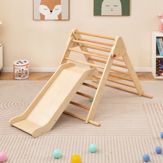 The natural wood climbing frame with slide set up on a rug with colourful balls scattered around