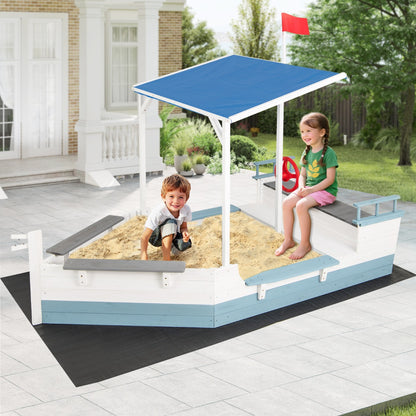 The pirate ship sandbox with canopy on a patio area with a house in the background
