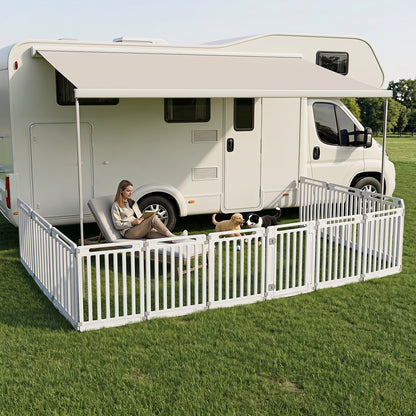 The pet gates used as an outdoor enclosure on grass next to a motorhome with dogs playing