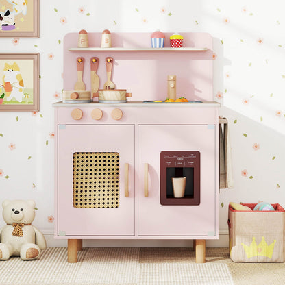 The pink play kitchen set in a child's bedroom with toys