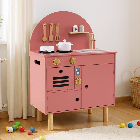 The pink wooden play kitchen set with accessories on a rug