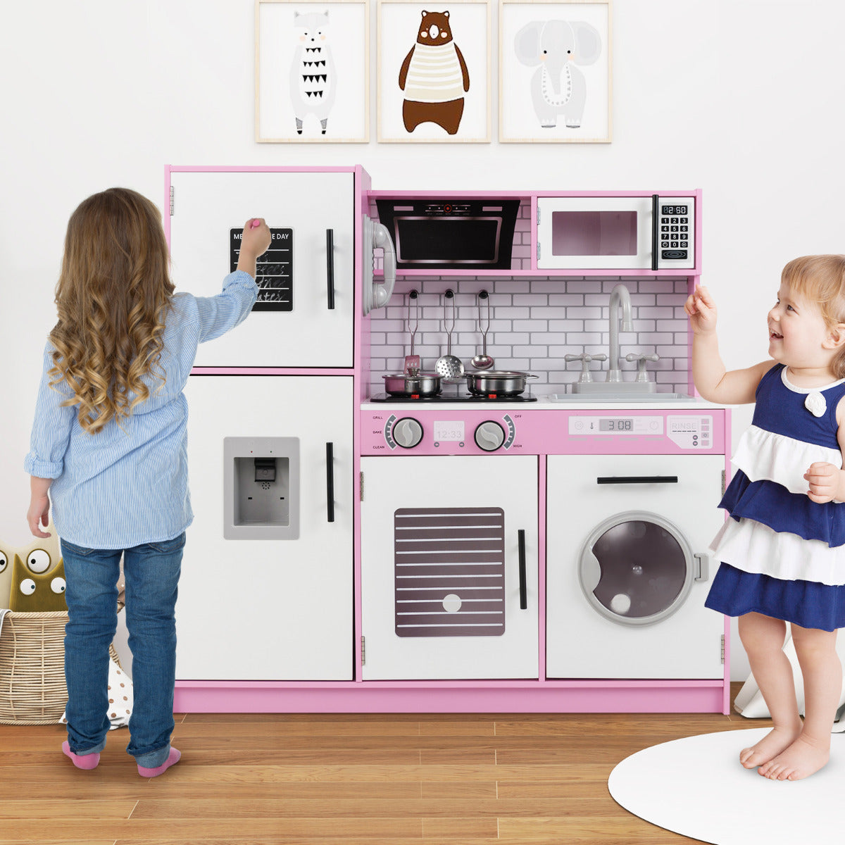 The play kitchen set being used by two young children in a bright playroom
