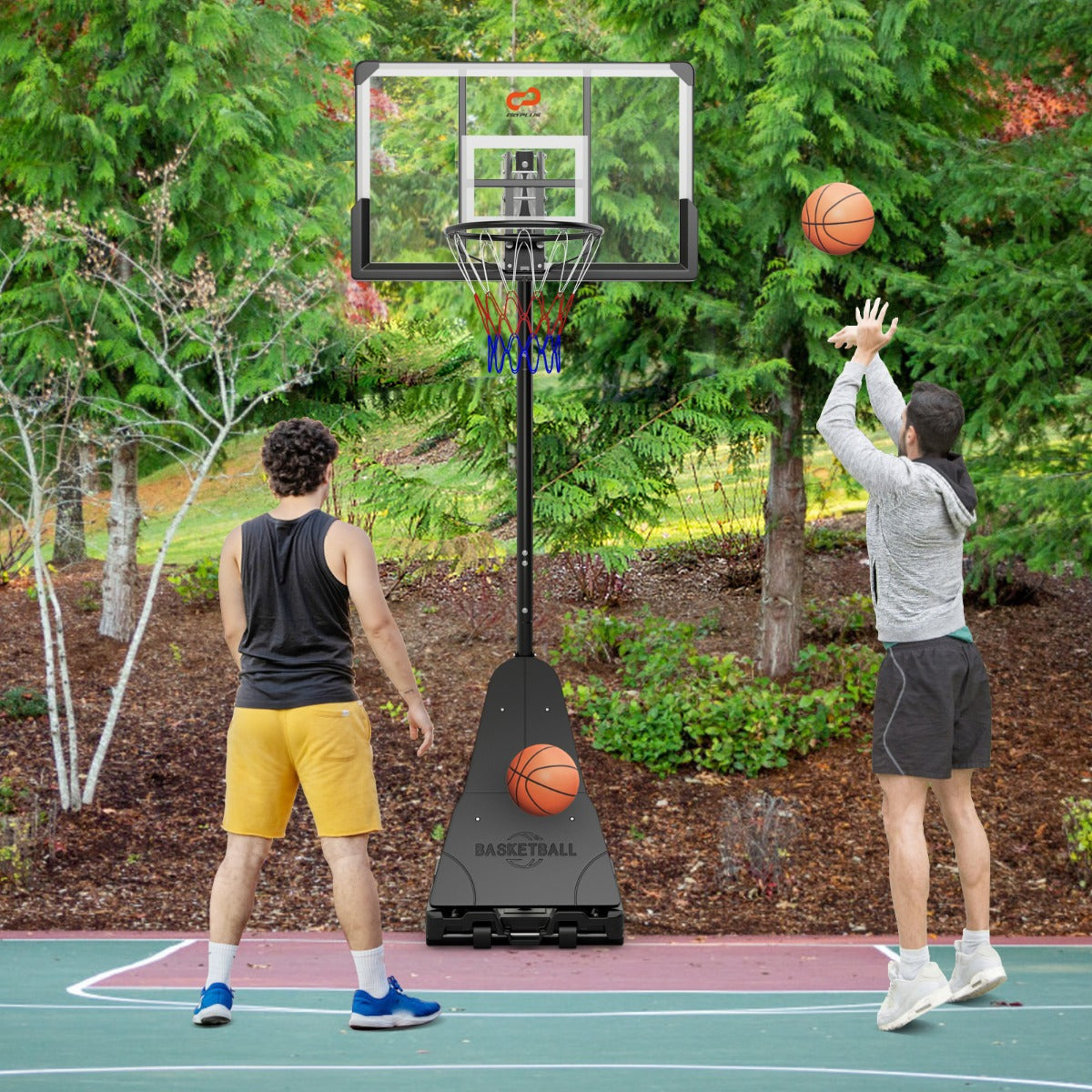 The sport equipment being used by two people playing basketball on an outdoor court