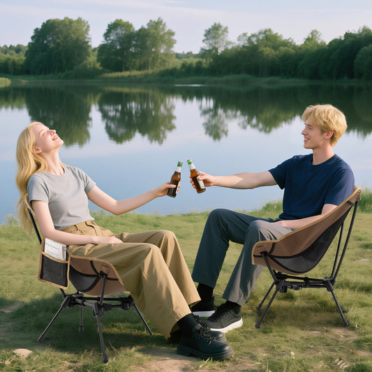 A couple enjoying drinks while sitting on the camping furniture by a lake