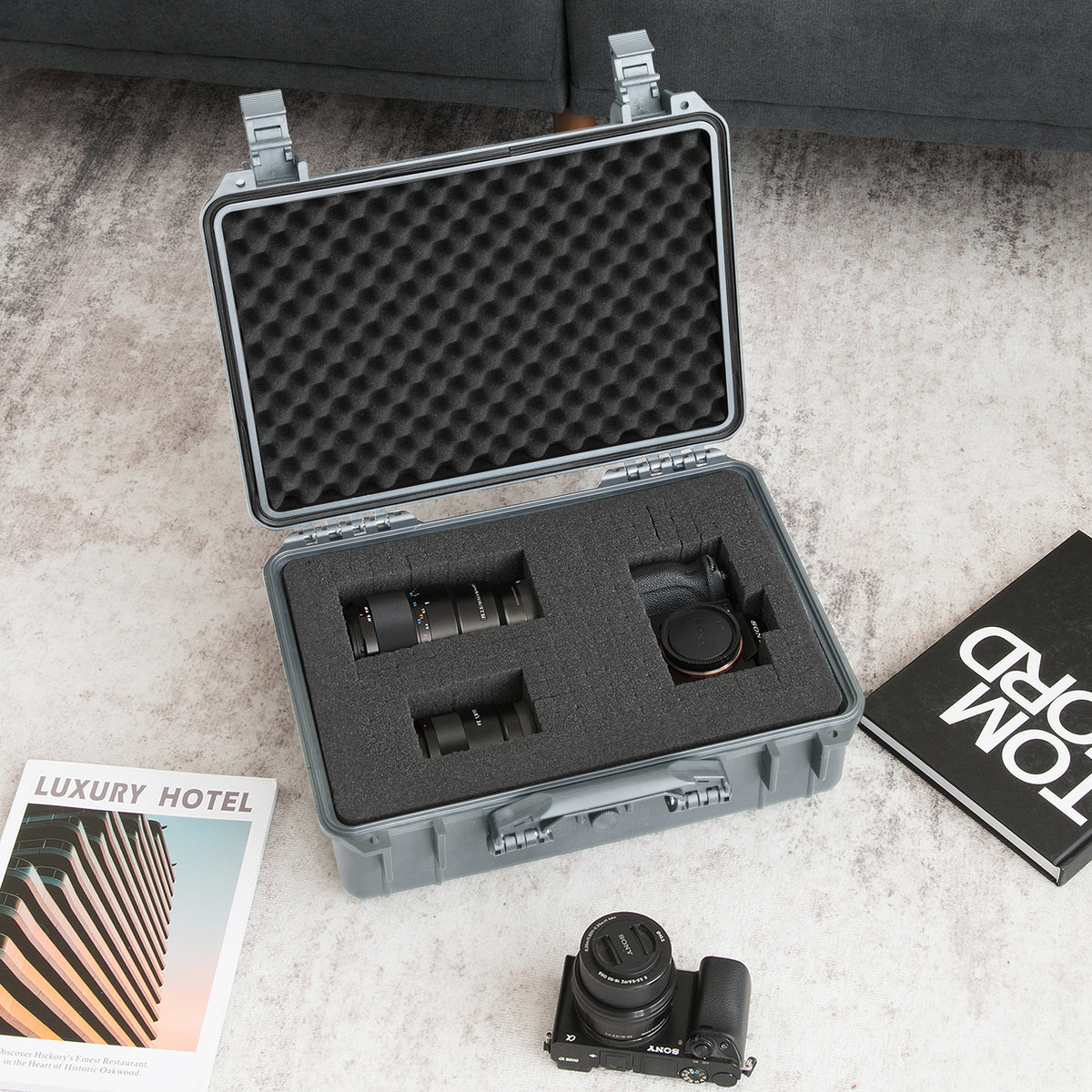 The camping case open on a rug holding camera lenses and a camera body