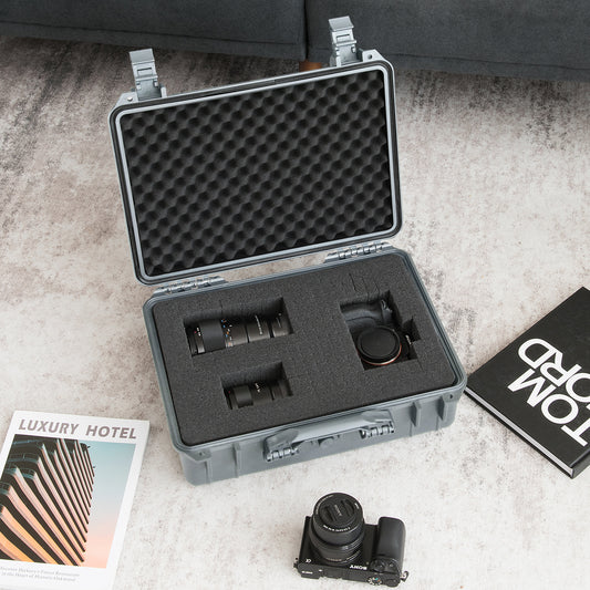 The camping case open on a rug holding camera lenses and a camera body