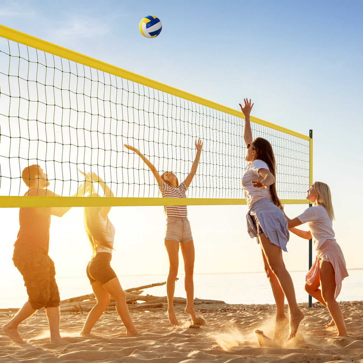 People playing volleyball on a beach with the yellow net system