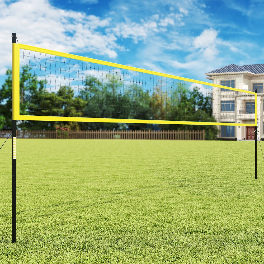 The yellow volleyball net system set up on a green lawn