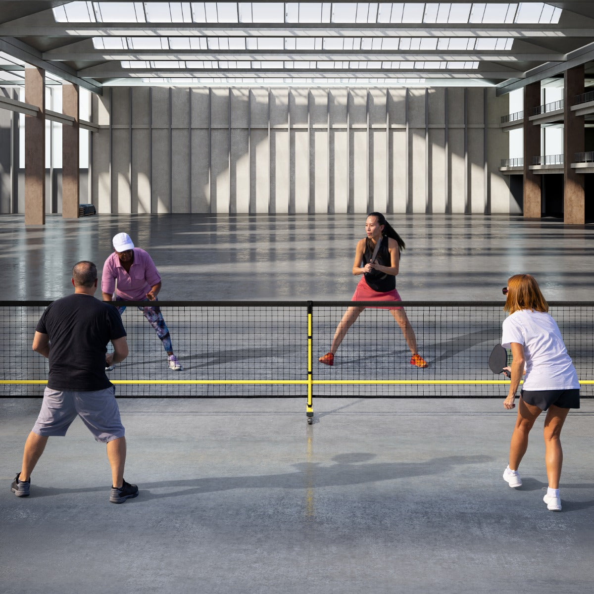 Portable Regulation Size Pickle Ball Net System, the sport equipment placed in a large indoor hall with people playing