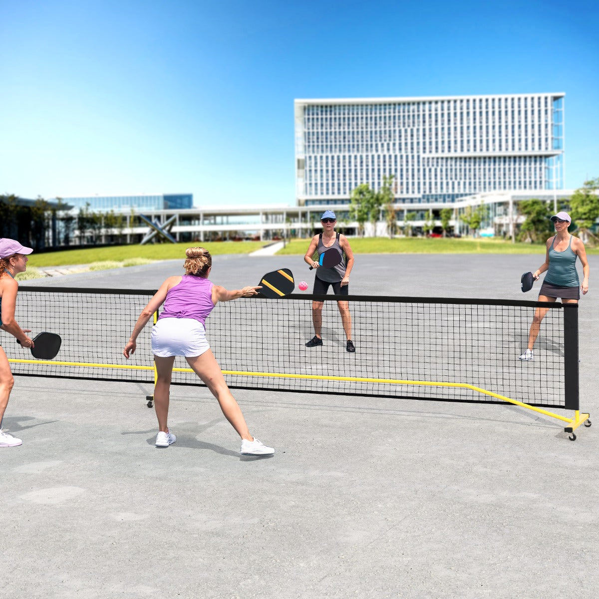 Portable Regulation Size Pickle Ball Net System, the sport equipment set up on an outdoor court with people playing a game