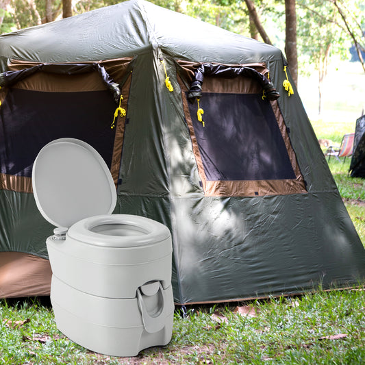 The grey portable toilet standing on grass in front of a large camping tent