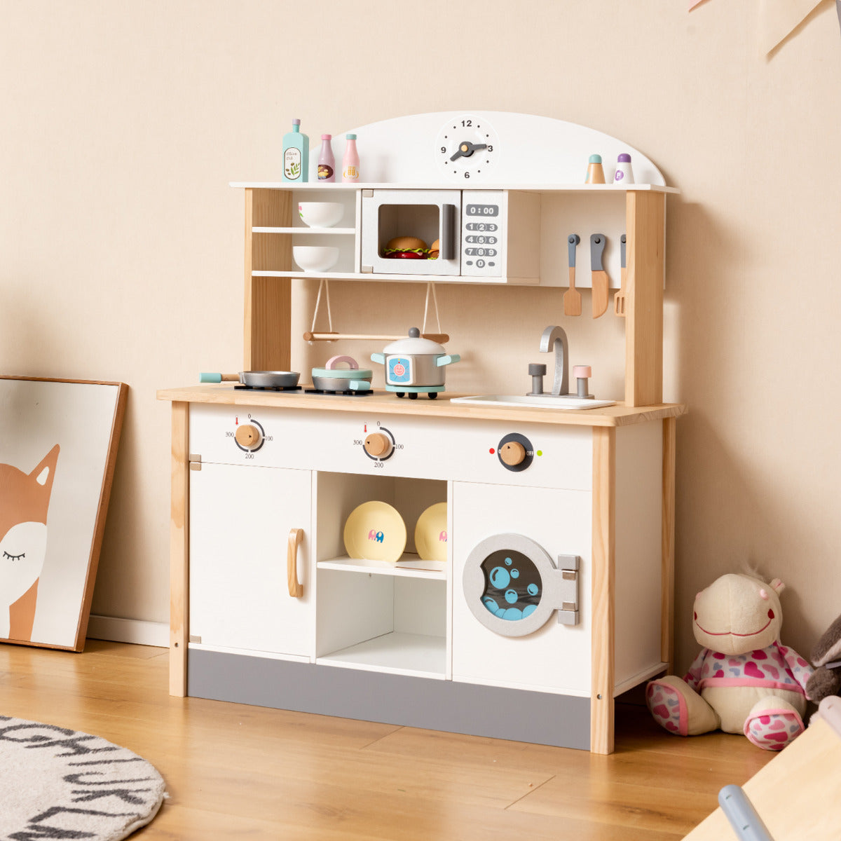 The play kitchen set stands in a child bedroom with a fox print and a stuffed toy on the floor