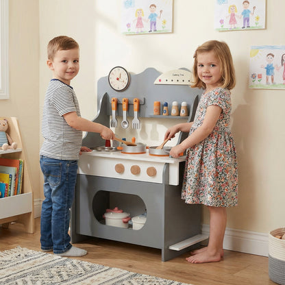 Two children playing with the grey toy kitchen set