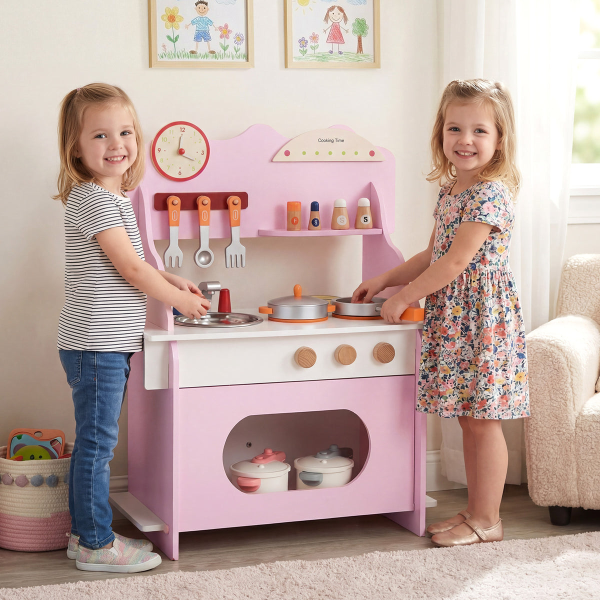 The play kitchen set being used by two children in a home environment with wall pictures