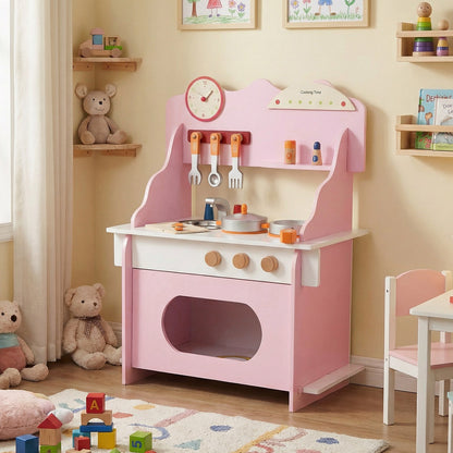 The play kitchen set positioned in a child's bedroom with soft toys and a rug on the floor