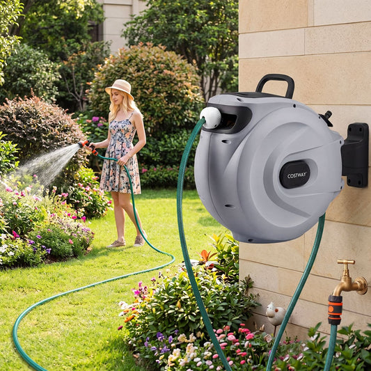 Woman watering flowers with the garden hose reel mounted on a brick wall