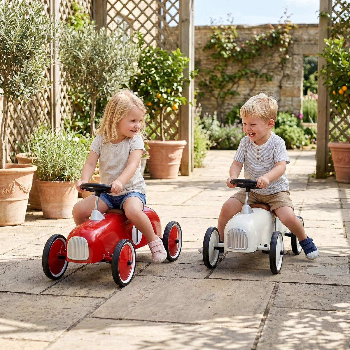 Two children playing with the riding toy in a sunny garden patio area