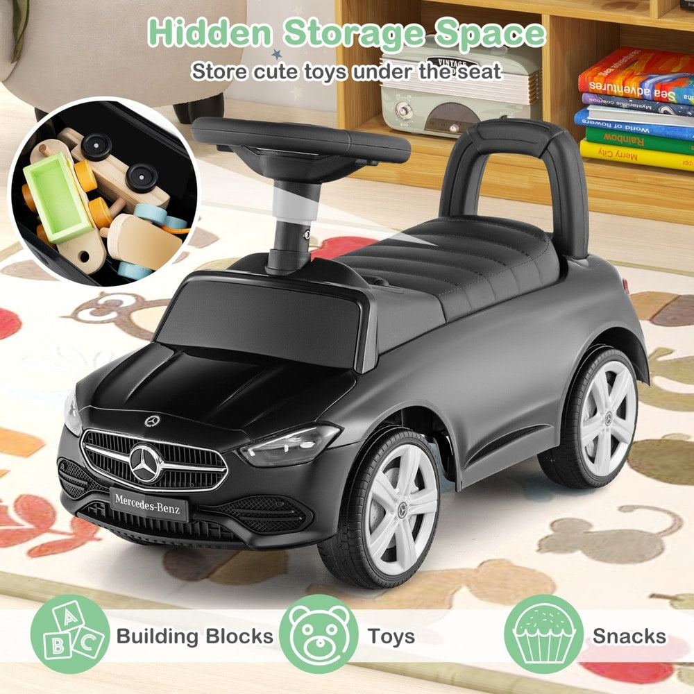 Black push and pedal ride on toy with storage compartment under the seat