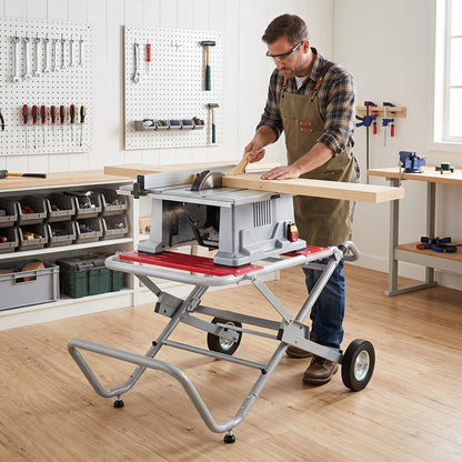 The metal base supporting a table saw while a man cuts a piece of wood in a workshop