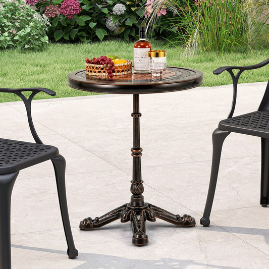 Bronze round patio table with carved texture, shown outdoors between two chairs