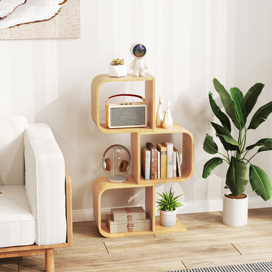 The bamboo bookcase standing in a bright living room next to a white sofa and a green plant