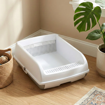White open-top cat toilet in a room with plants and a basket