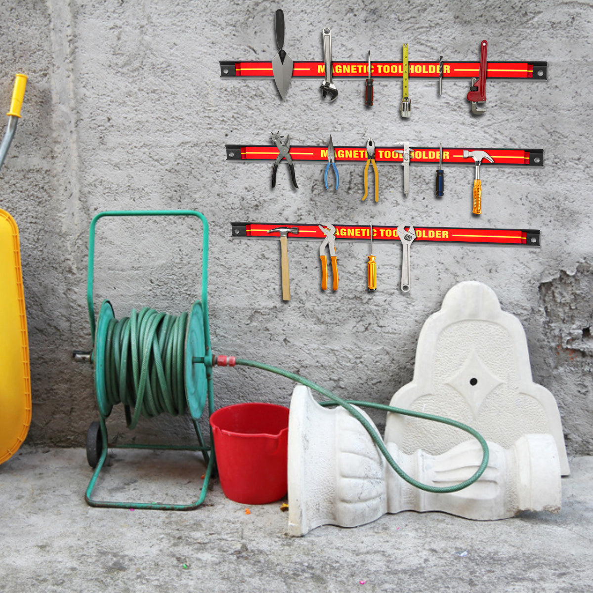 The magnetic storage bars fixed to a grey wall above a hose reel and garden items