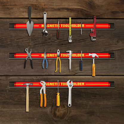 The magnetic tool holders mounted on a wooden wall holding various metal hand tools