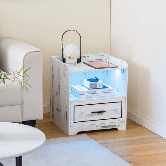 The smart LED nightstand is shown in a living room next to a sofa, with a lamp and books on top